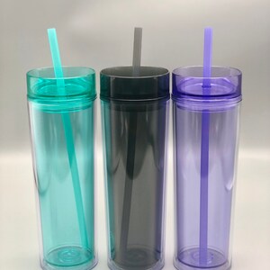 K&ouml;nnte beinhalten: Drei transparente, doppelwandige Becher mit Deckeln und Strohhalmen. Die Becher sind in den Farbt&ouml;nen T&uuml;rkis, Anthrazit und Lila gehalten. Jeder Becher hat einen farblich passenden Deckel und Strohhalm. Die Becher sind f&uuml;r kalte Getr&auml;nke konzipiert.