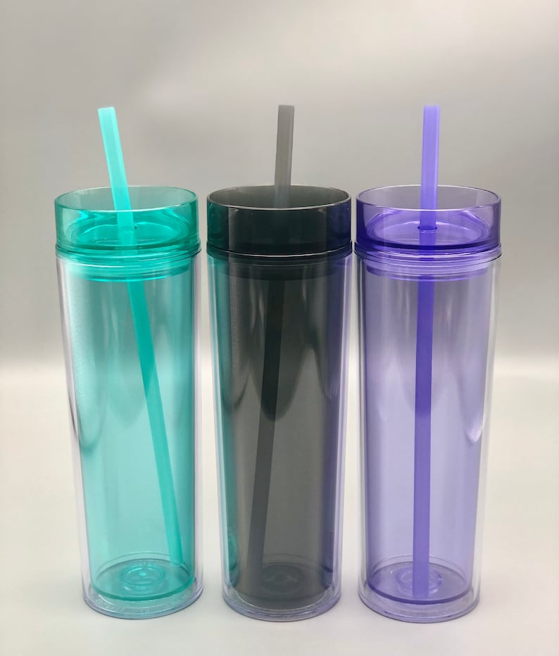 K&ouml;nnte beinhalten: Drei transparente, doppelwandige Becher mit Deckeln und Strohhalmen. Die Becher sind in den Farbt&ouml;nen T&uuml;rkis, Anthrazit und Lila gehalten. Jeder Becher hat einen farblich passenden Deckel und Strohhalm. Die Becher sind f&uuml;r kalte Getr&auml;nke konzipiert.