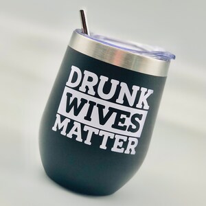 May include: Black stainless steel wine tumbler with a white inscription that reads "Drunk Wives Matter".