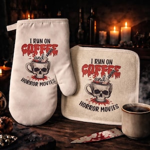 May include: Off-white oven mitt and pot holder set with a spooky design. The text "I RUN ON COFFEE and HORROR MOVIES" is printed in red and black. A skull cup with a knife is in the center. A ceramic mug with coffee is on the right.