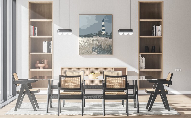 May include: A dining room with a glass table and six black chairs with woven cane seats. The table is set with a bowl of fruit. There are two wooden bookshelves on either side of the table, and a painting of a lighthouse on the wall behind the table.