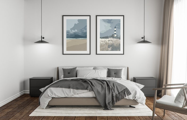 May include: A bedroom with a bed, two nightstands, and two framed prints of seascapes. The bed has a white duvet and a gray throw blanket. The nightstands are black and have two drawers each. The prints are black framed and feature a beach scene and a lighthouse.