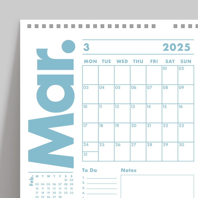 May include: A wall calendar for March 2025, featuring a light blue design. The calendar grid is displayed with dates and days of the week. Includes a section for notes and to-do lists. The word "Mar" is prominently displayed.