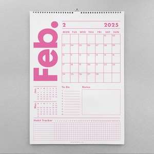 May include: A white wall calendar for February 2025, with a pink grid and text. The word "Feb." is vertically printed in large pink letters. Includes a "To Do" section, a "Notes" section, and a habit tracker.