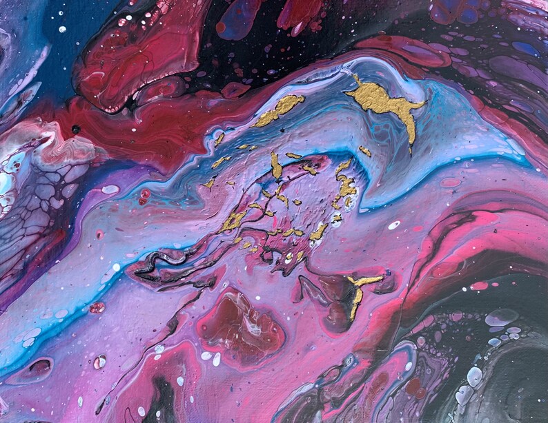 以下が含まれることがあります： ピンク、パープル、ブルー、ブラックのペイントが渦巻く抽象画。絵画は、金色のアクセントが施された銀河のような外観をしています。