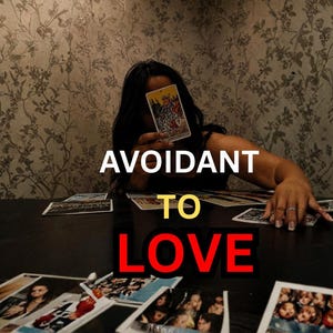 May include: A person holding a tarot card in front of their face, with the words "Avoidant to Love" in white, yellow, and red text. Several tarot cards and photos are on the dark table.