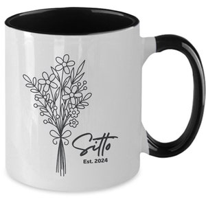 May include: White ceramic mug with a black rim and handle. The mug features a black line drawing of a bouquet of flowers and the text "Sitto Est. 2024".