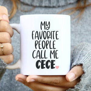 May include: White ceramic mug with black text that reads "My favorite people call me Cece" with a pink heart.