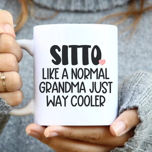 May include: White ceramic mug with black text that reads "Sitto like a normal grandma just way cooler" with a pink heart.