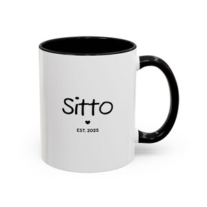 May include: White ceramic mug with a black rim and handle. The mug has black text that reads "Sitto Est. 2025" with a small heart symbol.