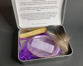 May include: A silver tin with a purple and white cleansing kit. The kit includes a pheasant feather, palo santo stick, selenite, and abalone shell. The text on the tin reads "Balanced Butterfly Travel Cleansing Kit Contains 4 Elements -Pheasant Feather represents Air-Selenite represents Earth -Palo Santo represents Fire-Abalone Shell represents Water I've incorporated the 4 elements to bring balance during each Cleansing. A small compact travel container filled with balance and peace. Use travel Cleansing Kit to cleanse yourself on the go. Light Palo Santo with flame. Turn to 45° until lit. Allow to burn for 30 seconds then blow out. Place palo santo in shell and use feather to fan smoke all over body or room to cleanse of unwanted energy Opening space for peace and clarification. Balanced Butterfly.net"