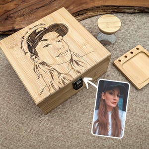 May include: A light-coloured wooden box with a portrait engraved on the lid, a small wooden tray, and a small hourglass. The box has a metal clasp. The text "Your Personal Message Engraved Here" is on the lid. A photo is next to the box.