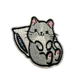 Könnte beinhalten: Gestickter Bügel-Patch mit einer grauen Katze mit rosa Ohren und einem weißen Kissen. Die Katze liegt auf dem Kissen zusammengerollt, die Pfoten sind eingezogen.