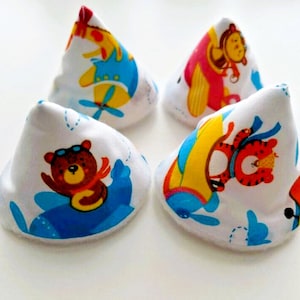 May include: Four cone-shaped fabric items featuring colorful cartoon animal prints. Each white piece displays illustrations of bears, tigers, and monkeys piloting small airplanes in shades of blue, yellow, and red, arranged in a square formation.
