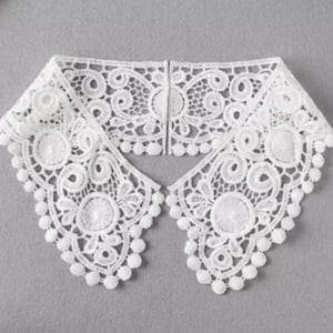 May include: White lace collar with a scalloped edge and a delicate floral pattern. The collar is made of a soft, lightweight fabric and has a vintage look.