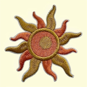 May include: An embroidered sun patch featuring a central circular core in golden yellow, surrounded by a ring of burnt orange, and radiating wavy points that alternate between golden yellow and burnt orange, all outlined in a light grey thread.