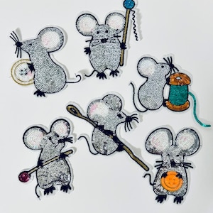 May include: Six silver sequin mouse appliques with various details, including a spool of thread, a ball of yarn, and a stick.