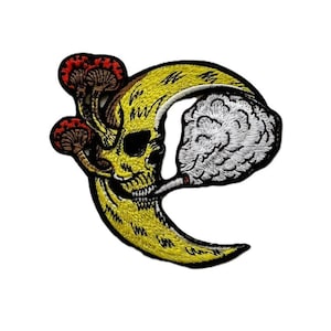 May include: Embroidered patch depicting a yellow skull-shaped crescent moon smoking a cigarette, with two red and brown mushrooms. The patch has black outlines and white smoke.