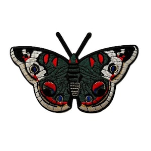 May include: Embroidered green butterfly patch with red, white and blue accents. The butterfly has large, round eyes.