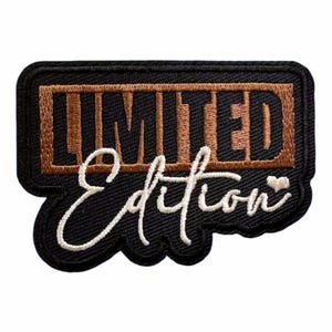 May include: A rectangular embroidered patch with a black border and background. It features the word LIMITED in bold, blocky brown letters inside a brown rectangular frame, with the word Edition in white cursive script and a small heart.