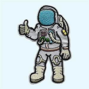 May include: An embroidered patch featuring an astronaut in a white space suit with a bright blue helmet visor. The astronaut is giving a thumbs-up gesture with the right hand. The suit includes detailed stitching in shades of gray, tan, and green.