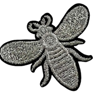 May include: A silver embroidered bee patch with a black outline. The bee has a detailed body and wings.
