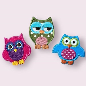 May include: Three embroidered owl patches. One is green with white polka dots, one is pink with purple polka dots, and one is blue with pink polka dots.
