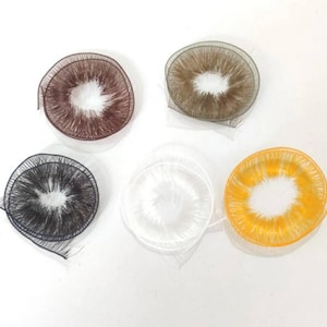 May include: Five different coloured eye lashes for doll making. The lashes are in a circle shape and are made of a soft, fluffy material. The colours are brown, grey, white, yellow, and orange.