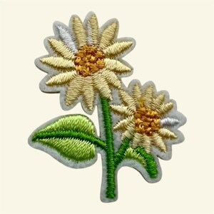 May include: An embroidered patch featuring two sunflowers with pale yellow petals and dark yellow centers. The design includes a single bright green leaf attached to a green stem, all outlined with a light gray border on a plain background.