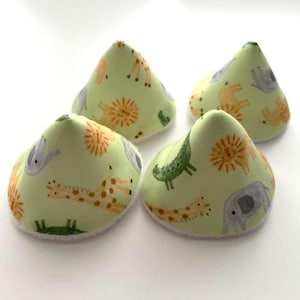 May include: Four cone-shaped fabric covers featuring a light green background with a repeating pattern of illustrated animals including lions, giraffes, elephants, and crocodiles. Each piece has a soft white trim along the circular base edge.