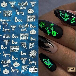 May include: Halloween-themed nail art stickers with various designs, including pumpkins, spiderwebs, and the words "Halloween Party" and "Spooky." The image also shows examples of the stickers applied to nails, glowing in the dark.