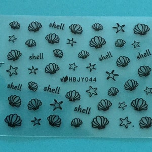 May include: A sheet of clear nail decals with black outlines of seashells and starfish. The sheet has the text "shell" repeated multiple times and the code "HBJY044".