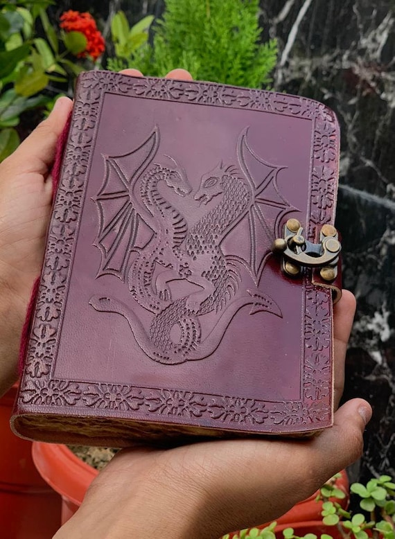 Hand-embossed double-dragon Celtic leather journal — the intricate raised dragon artwork makes this a legitimate display piece as much as a writing book.