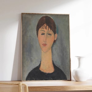 May include: A framed painting of a woman with short brown hair. The woman is wearing a black shirt and has a light blue background.