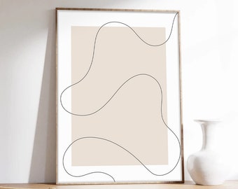 May include: A framed abstract print with a beige background and black line drawings of wavy shapes. The print is hanging on a white wall above a wooden desk with a chair.