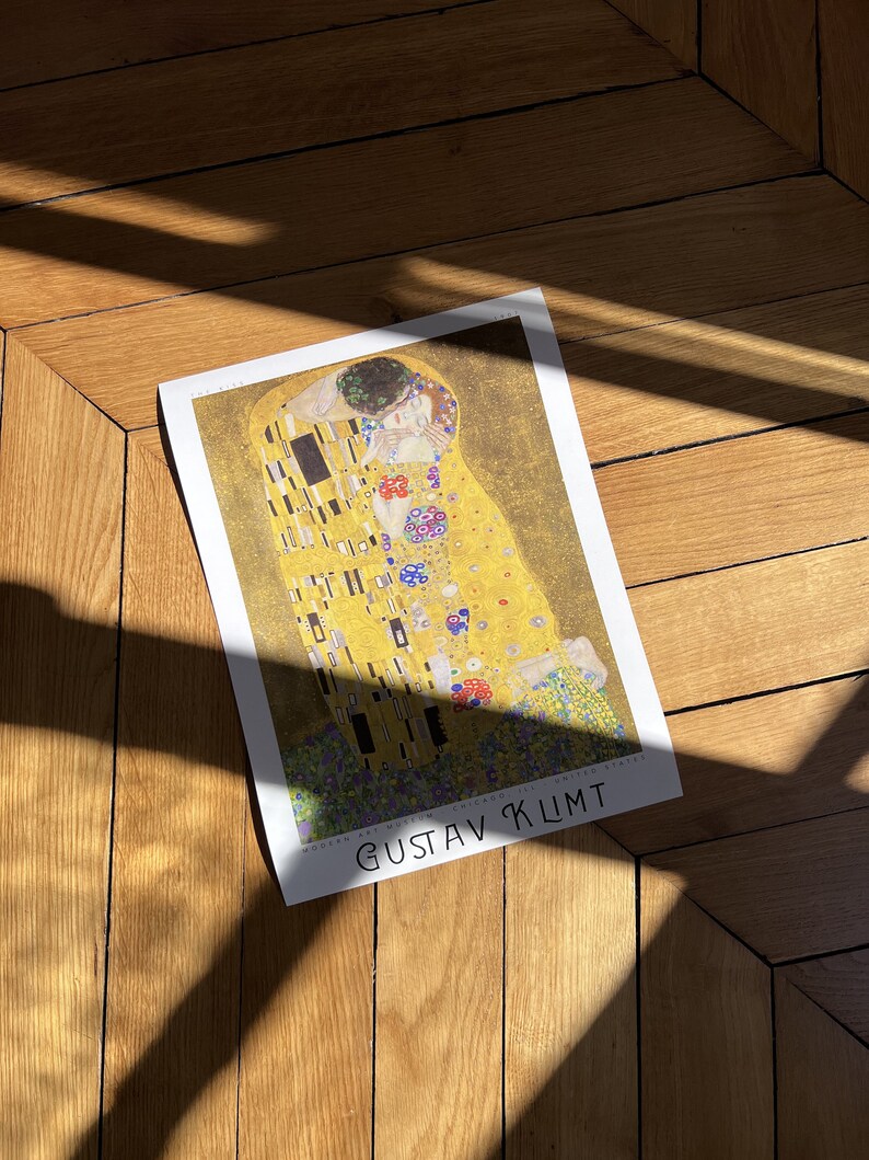 Pu&ograve; includere: Un poster del dipinto "Il Bacio" di Gustav Klimt. Il dipinto presenta due figure in un abbraccio dorato, circondate da motivi intricati e floreali.