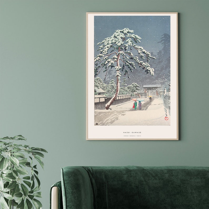 May include: A woodblock print of a snowy Japanese landscape with a large pine tree in the foreground. Two figures walk along a path with umbrellas. The print is titled "Kasui Kawase" and is signed "Hiroshige Ando" in the lower right corner.