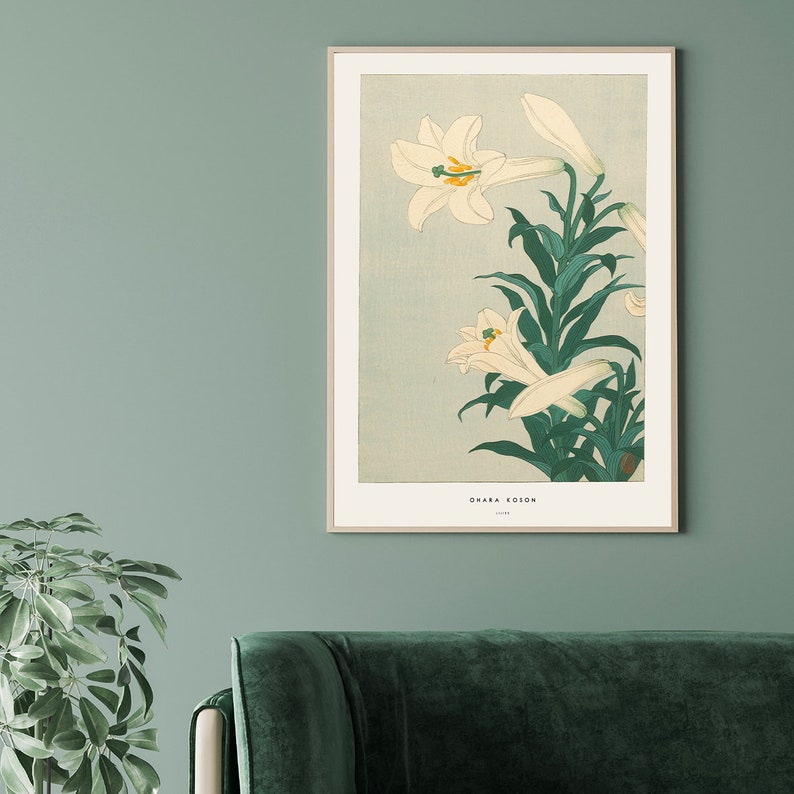 May include: A vintage Japanese woodblock print of white lilies with green leaves on a light blue background. The print is titled "Ohara Koson" and is framed in a white frame.