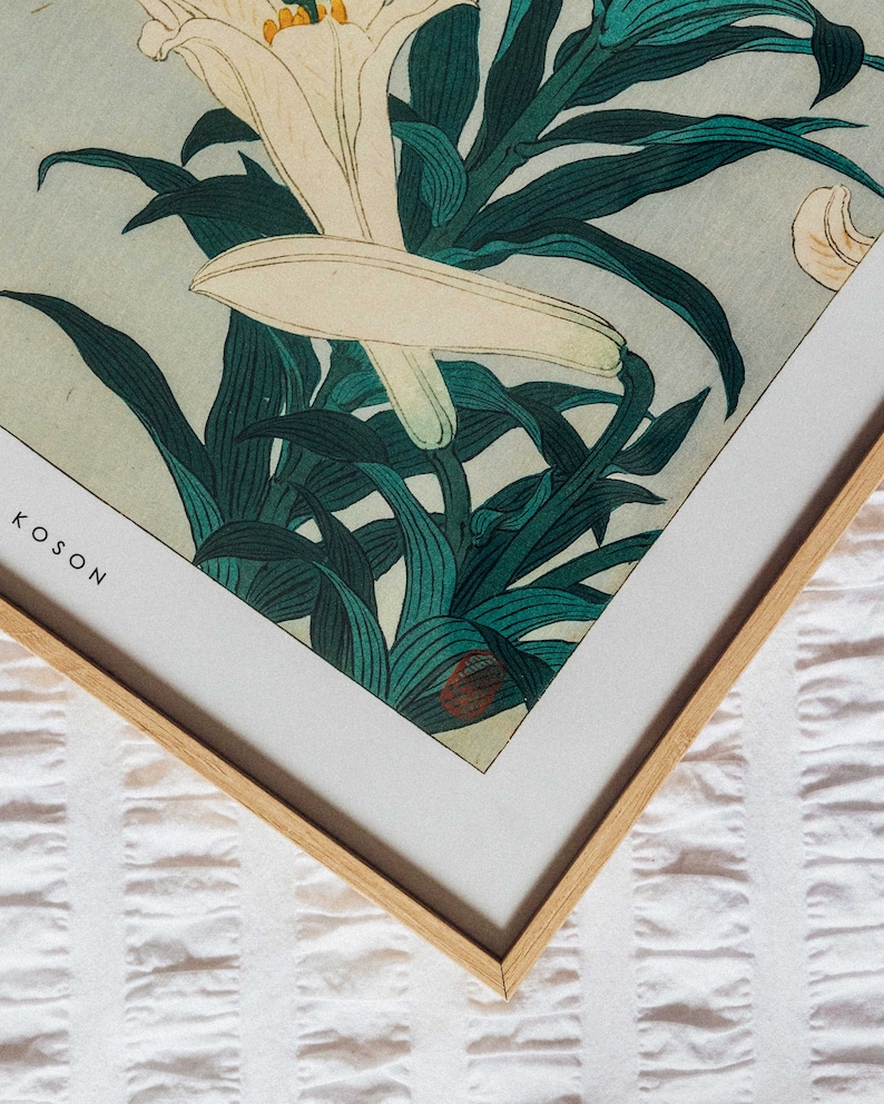 May include: A framed print of a Japanese woodblock print featuring white lilies and green leaves. The print is titled "Koson" in the bottom left corner.