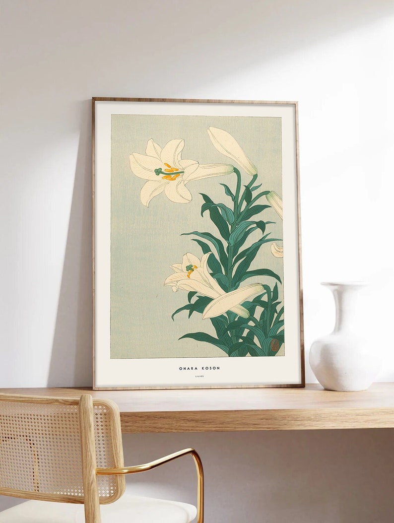 May include: A framed print of a Japanese woodblock print featuring white lilies with green leaves on a light blue background. The print is titled "Ohara Koson" with the year "1918" below the title.