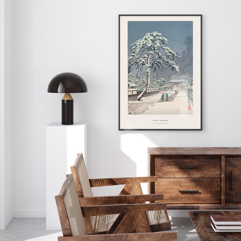 May include: A framed print of a Japanese woodblock print depicting a snowy scene with a pine tree and figures walking on a path. The print is titled "Yuki-Gama" and is by the artist Kawase Hasui.