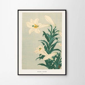 May include: A vintage Japanese woodblock print of white lilies with green leaves on a light blue background. The print is signed "Ohara Koson" in the bottom right corner.