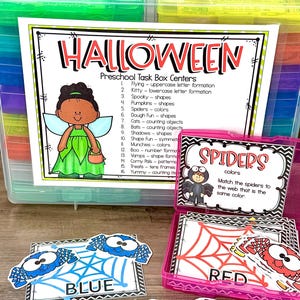 May include: A Halloween-themed preschool task box set. The set includes cards with spiders, pumpkins, and other Halloween-related images. The cards are designed to teach shapes, colors, and counting. The set is in a clear plastic container.