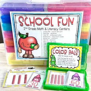 May include: A clear plastic storage container filled with colorful compartments, labeled "SCHOOL FUN" and "COLOR PALS." Includes math and literacy learning materials, such as cards with base ten blocks and crayon illustrations. Educational tools for 2nd grade.