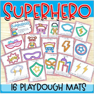 May include: A collection of 16 rectangular playdough mats featuring superhero-themed illustrations and text. Each card displays a colorful graphic, such as masks, shields, lightning bolts, and buildings, with the phrase I can make a below it.