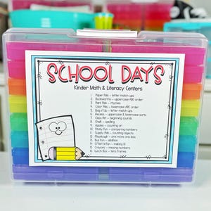 May include: A clear plastic storage box with colorful compartments. The box is labeled "School Days" and lists activities for kindergarten math and literacy centers. The activities include letter matching, rhyming, counting, and more.