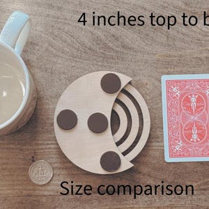 May include: A wooden coaster with three brown circular magnets, a playing card, a pencil, a mug, and a coin are displayed on a wooden surface. The text "4 inches top to bottom" and "Size comparison" are visible.