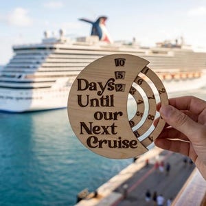May include: A circular wooden countdown calendar featuring the text "Days Until our Next Cruise" with rotating rings displaying numbers. The design includes a crescent-shaped cutout revealing inner numerical wheels for tracking time until a trip.