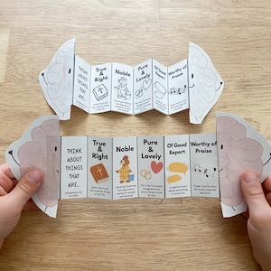 May include: A folded paper craft with brain-shaped ends, featuring text and illustrations. The text includes phrases like "Think About Things That Are," "True & Right," and "Noble." The illustrations depict a bible, a person helping others, and a heart.
