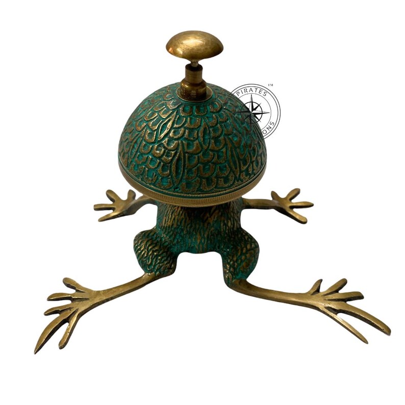 May include: A green and gold frog-shaped brass bell with a decorative top. The bell is a home decor item.